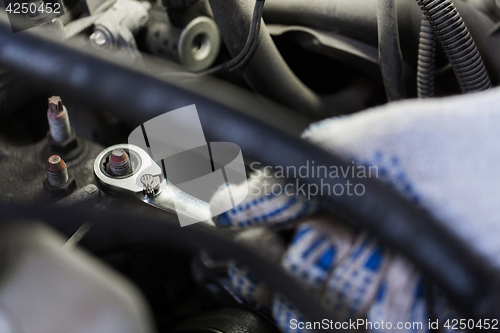 Image of mechanic man with wrench repairing car at workshop