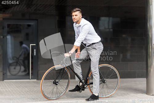 Image of man with bicycle and headphones on city street