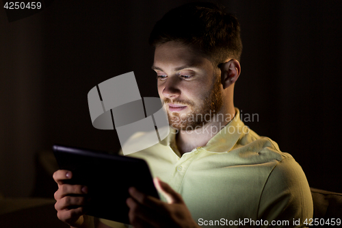 Image of young man with tablet pc computer at night