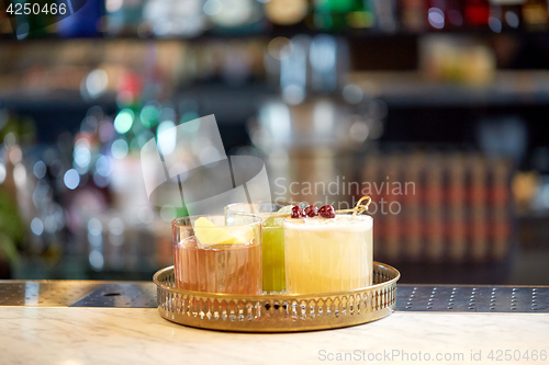 Image of tray with glasses of cocktails at bar