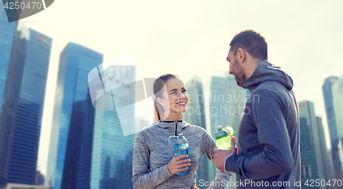 Image of smiling couple with bottles of water outdoors