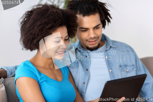 Image of smiling happy couple with tablet pc at home
