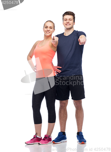 Image of happy sportive man and woman pointing finger