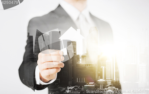 Image of close up of businessman holding paper house