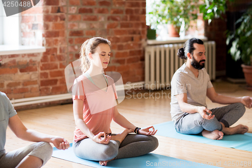 Image of group of people making yoga exercises at studio