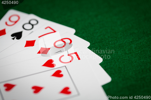 Image of poker hand of playing cards on green casino cloth