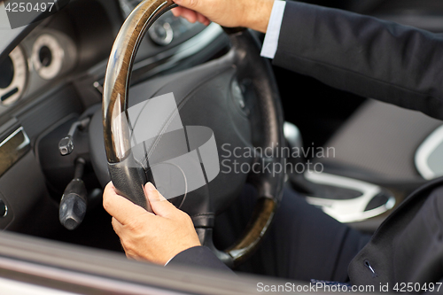 Image of senior businessman hands driving car