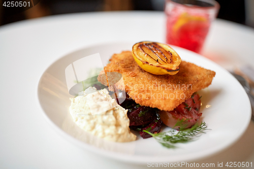 Image of close up of fish salad with roasted lemon on plate