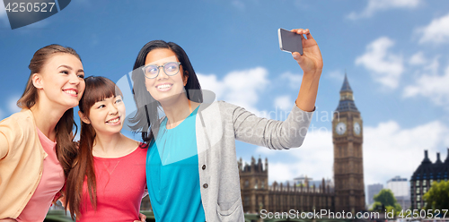 Image of international happy women taking selfie at london