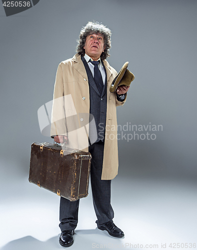 Image of The senior man as detective or boss of mafia on gray studio background