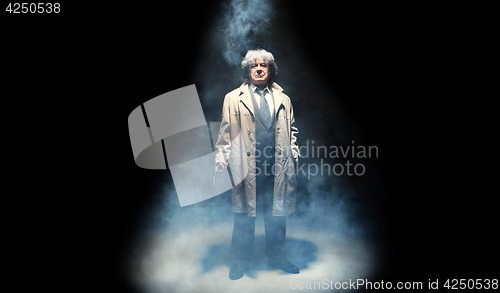 Image of Senior police agent with a gun on dark smoke background