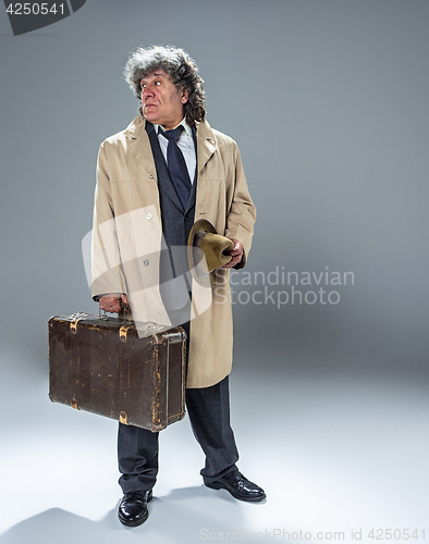 Image of The senior man as detective or boss of mafia on gray studio background