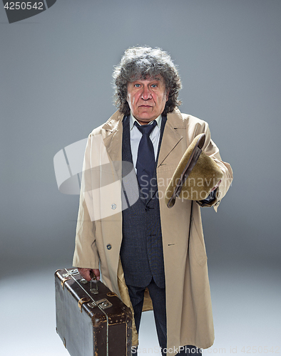 Image of The senior man as detective or boss of mafia on gray studio background