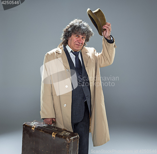 Image of The senior man as detective or boss of mafia on gray studio background