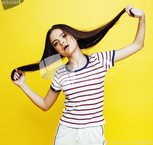 Image of lifestyle people concept: pretty young school teenage girl having fun happy smiling on yellow background