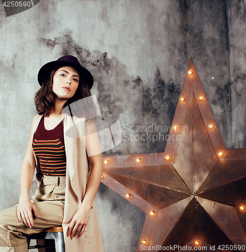 Image of young pretty woman waiting alone in modern loft studio, hipster in hat, fashion musician concept, lifestyle people 