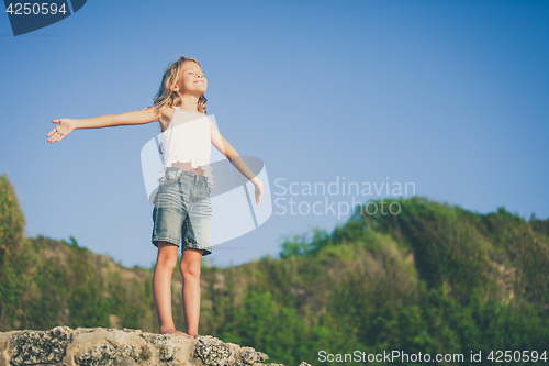 Image of Happy little girl  standing on the beach