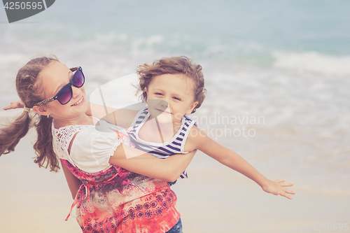 Image of Sister and brother playing on the beach at the day time.