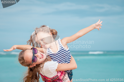 Image of Sister and brother playing on the beach at the day time.