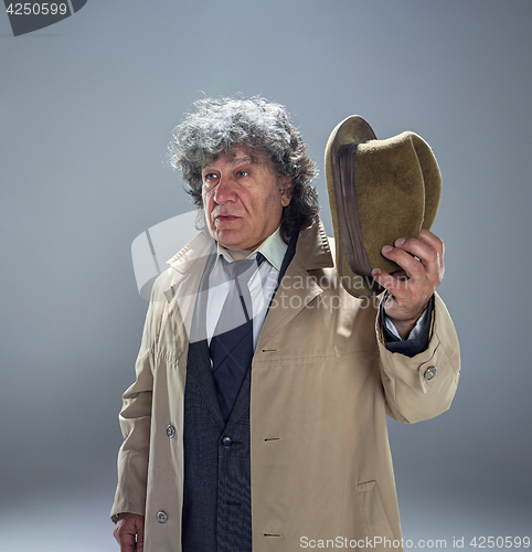 Image of The senior man as detective or boss of mafia on gray studio background