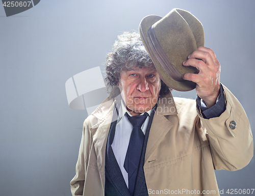 Image of The senior man as detective or boss of mafia on gray studio background