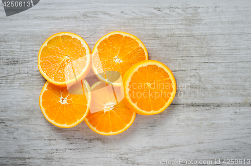 Image of Slices of fresh oranges on white wood background