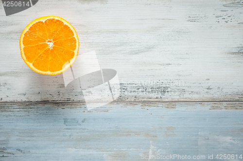 Image of One slice of fresh oranges on painted wooden board