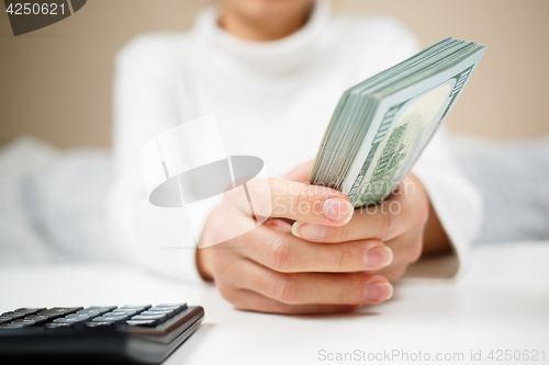 Image of Woman hand hold cash dollar banknotes. Only hundreds.