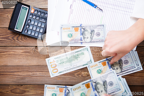 Image of Hands hold and counting us dollar banknotes