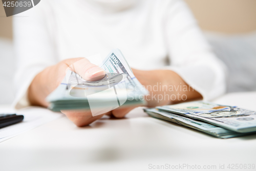 Image of Hands of person proposing money to you - closeup shot