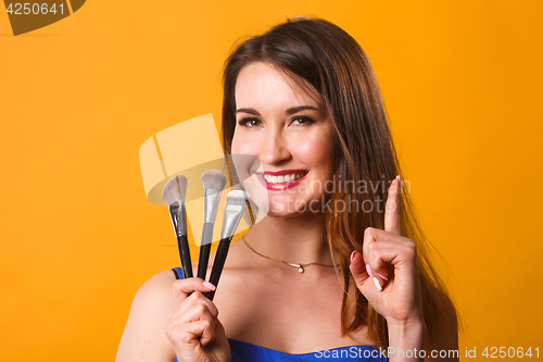 Image of Beautiful woman with makeup brushes