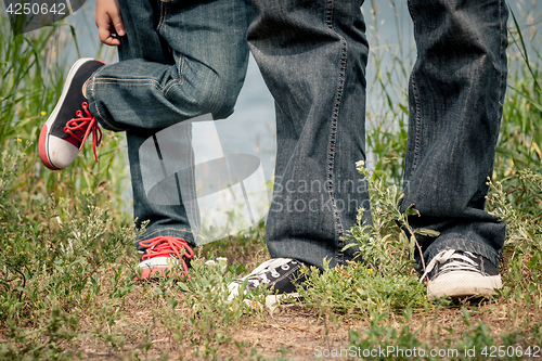 Image of Father and son playing at the park near lake at the day time.