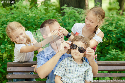 Image of Father and children playing at the park at the day time.