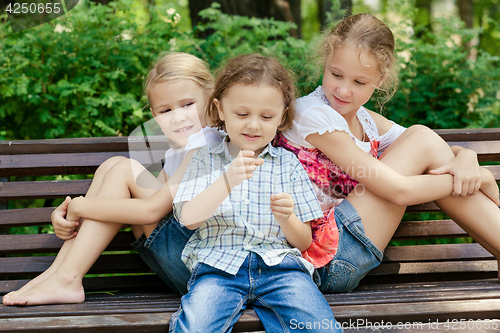 Image of Three happy children  playing in park