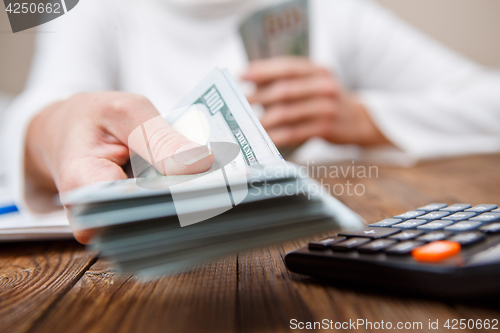 Image of Hands of person proposing money to you - closeup shot