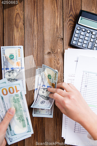 Image of Hands hold and counting us dollar banknotes