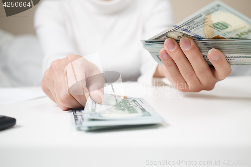 Image of Close up of woman with calculator counting money