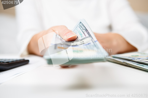 Image of Hands of person proposing money to you - closeup shot