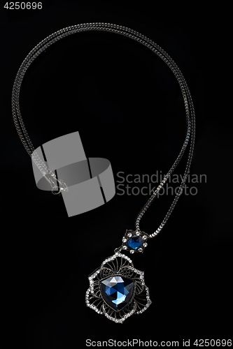 Image of blue necklace on a black background. gems. 