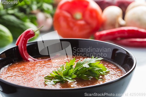 Image of tomato soup in a black plate. 