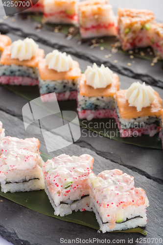 Image of set of sushi on a slate square plate. 