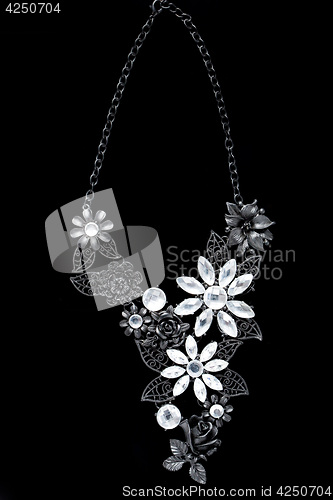 Image of necklace on a black background. gems. 