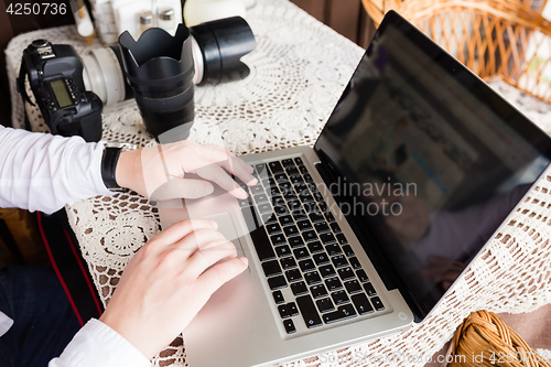 Image of happy young man working on laptop outdoors