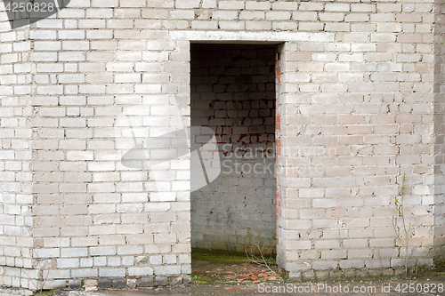 Image of white cracked brick wall with a doorway