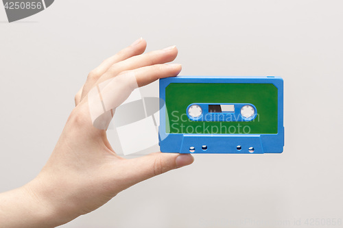 Image of hand holding blue cassette tape