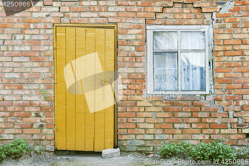 Image of red brick wall, wooden door and window