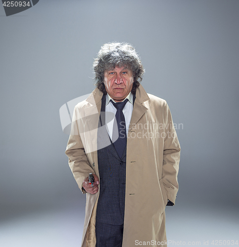 Image of Senior police agent with a gun on dark smoke background