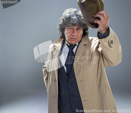 Image of The senior man as detective or boss of mafia on gray studio background