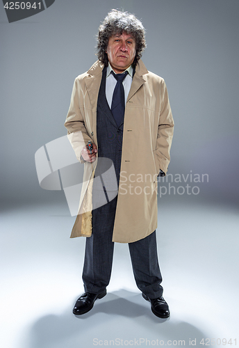 Image of Senior police agent with a gun on dark smoke background