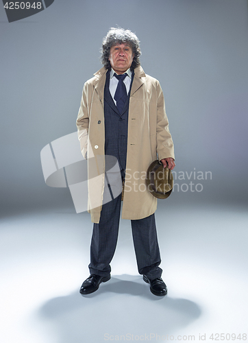 Image of The senior man as detective or boss of mafia on gray studio background